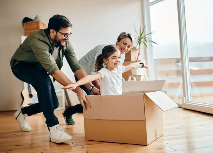 Família feliz fazendo mudança - pai, mãe e filha brincando com caixas